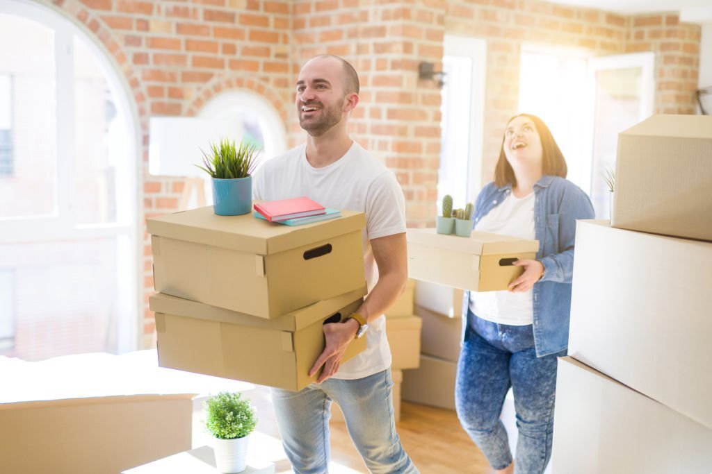 A man and women moving the boxes.